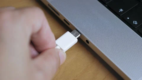 A man inserts a Type C cable into a laptop connector. Stock Footage 204929275