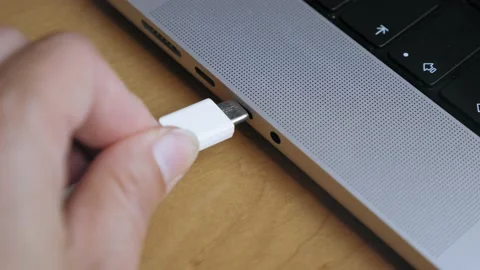 A man inserts a Type C cable into a laptop connector. Data transfer from phone Stock Footage 205567466