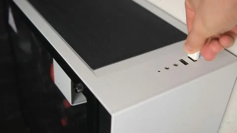 A man inserts a USB stick into the USB port of a computer, a white system unit o Stock Footage 147868601