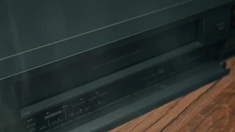Man Inserts a VHS Cassette Tape Into a Vintage VCR Player Video stock 330251775
