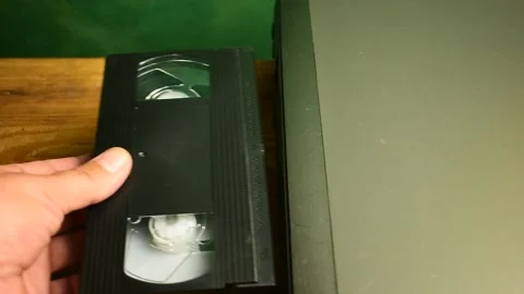 Man inserts a video cassette into a VCR Stock Footage 138143771