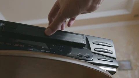 Man inserts the video cassette into the VHS/S-VHS videorecorder Stock Footage 78118225
