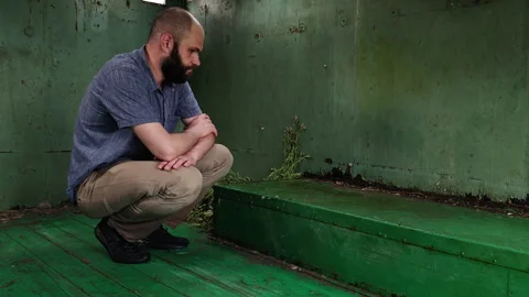 Man Inside Abandoned Trailer Looking at Wet Floor After Rain Stock Footage 339591025