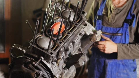A man inspect, turns the engine in different directions. Stock Footage 90855477