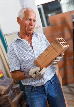 Man inspecting brick for installing wall Foto stock