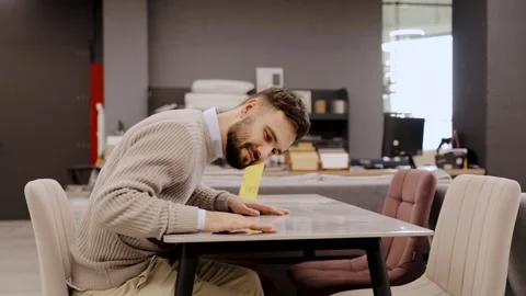 Man inspecting dining table surface in furniture store Stock Footage 322550121