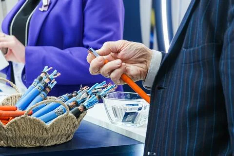 Man inspecting electrical wire at industry exhibition. Professional expert Stock Photos