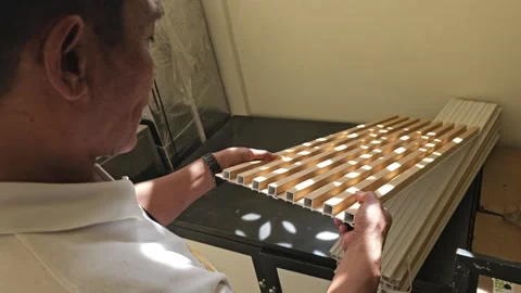 Man Inspecting Flexible WPC Fluted Wall Panel Sample For Interior Design Stock Footage 340001658