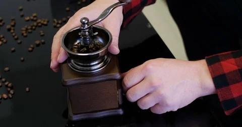 Man inspecting fresh grounded coffee beans from an antique traditional grinder. Video stock 104406304