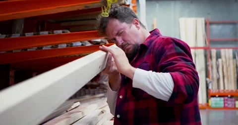 Man Inspecting Lumber in Hardware Store Aisle Stock Footage 323778420
