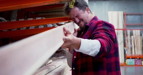 Man Inspecting Lumber Quality in Warehouse 库存影片 323778640