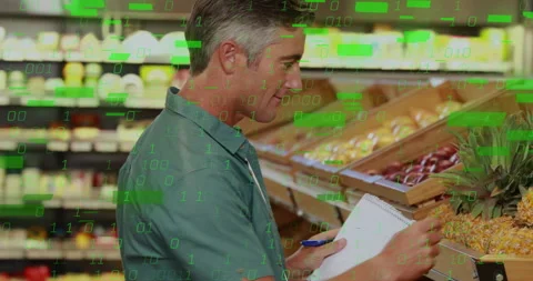 Man inspecting pineapples and noting in produce aisle, causing green binary Stock Footage 312904913