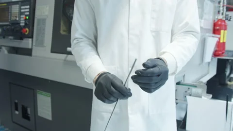 Man inspecting the quality of a titanium bar at factory. Stock Footage 152447892