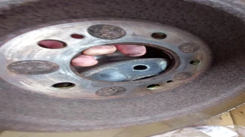 Man inspecting a rusty inner side of a car brake disc rotor Stock Footage 336004934
