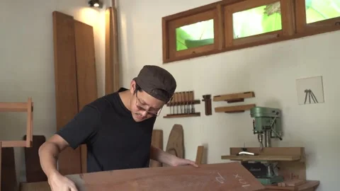 Man inspecting wooden board inside woodworking workshop before carpentry Stock Footage 340601419
