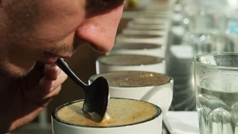 Man inspector smells coffee stirring beverage with spoon Stock Footage 264351461