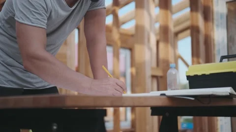 A man inspects and makes a plan for the construction of a house. Stock-Footage 139038032