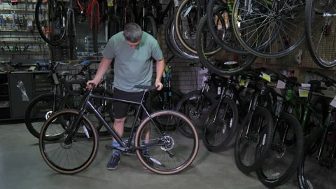 A man inspects a bicycle for purchase Stock Footage 205860622