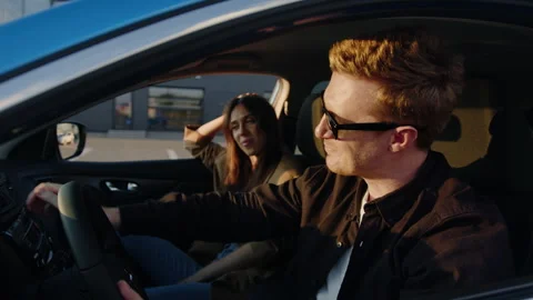 Man inspects the interior of a new car against the background of a joyful woman Stock Footage 256074128