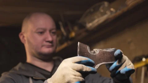 A man inspects the marked billet axe Stock Footage 129040389