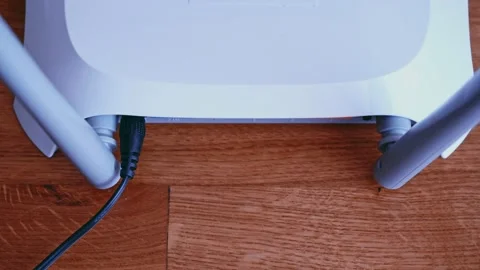 Man install Ethernet network Patch Cable on router. Wireless Router On The Desk Stock Footage 157890437