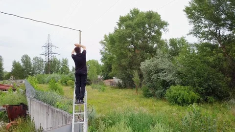 Man install a security camera on the pillar Stock Footage 94917436