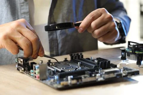 Man installing computer chip onto motherboard at wooden table, closeup Foto stock