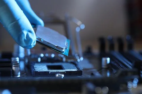 Man installing computer chip onto motherboard at table, closeup Stock-Fotos