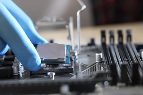 Man installing computer chip onto motherboard at table, closeup Stock-Fotos