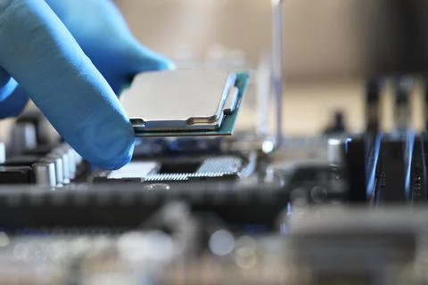 Man installing computer chip onto motherboard at table, closeup Foto stock