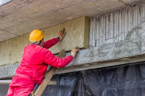 Man installing external wall insulation Stock Photos