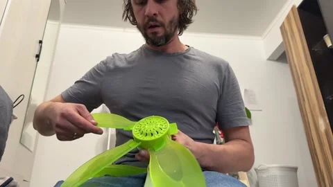 Man installing fan blades onto small device, assembling ventilation unit and Stock Footage 337109997
