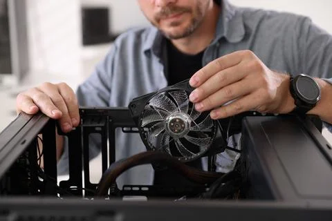 Man installing fan into computer at table, closeup Foto stock