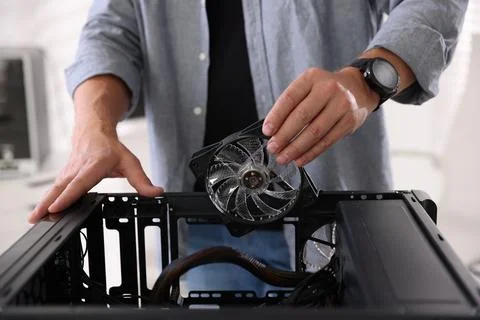 Man installing fan into computer at table, closeup 스톡 사진