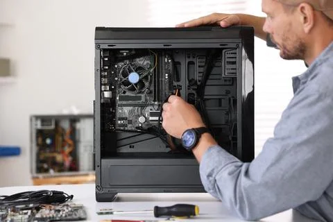 Man installing fan into computer at white table Foto stock