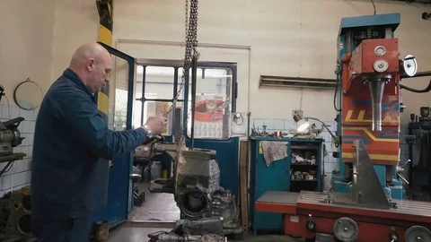 Man installing gear box of kamaz on a boring machine in old shabby car service. Stock-Footage 81541774