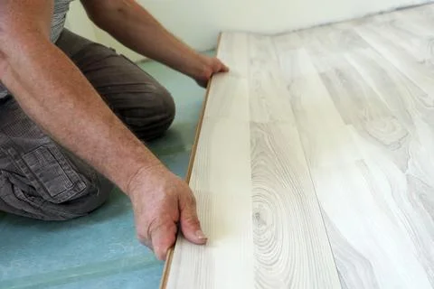 A man is installing a laminate on the floor close-up Stock Photos