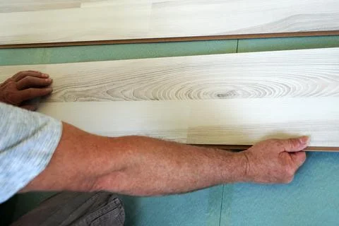 A man is installing a laminate on the floor close-up Stock Photos