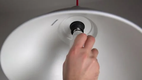 Man installing light bulb on ceiling light Stock Footage 160818617