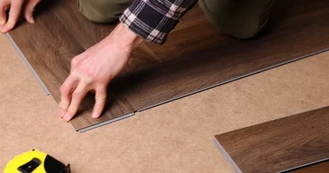 Man installing new vinyl tile wood texture flooring in a herringbone pattern 動画素材 331258252
