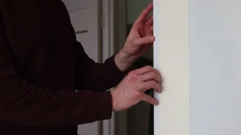 Man installing protective decorative corner on the wall in apartment. Video stock 169244131