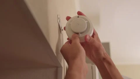 Man installing smoke detector on ceiling near doorway, professional technician Stock Footage 347877179