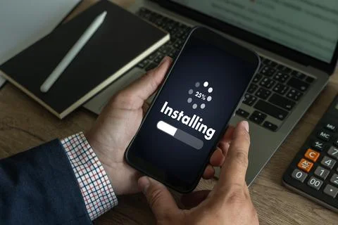 Man installing Software Update On Mobile Phone And Laptop digital technolog.. 写真素材