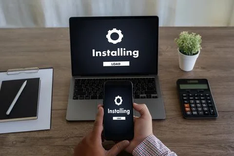 Man installing Software Update On Mobile Phone And Laptop digital technolog.. Stock Photos
