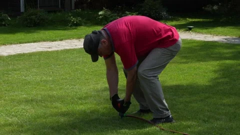 Man installing sprinkler on lawn Stock Footage 277421997