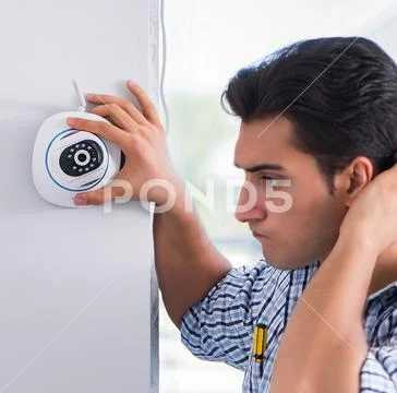 Man installing surveillance CCTV cameras at home Stock Photos