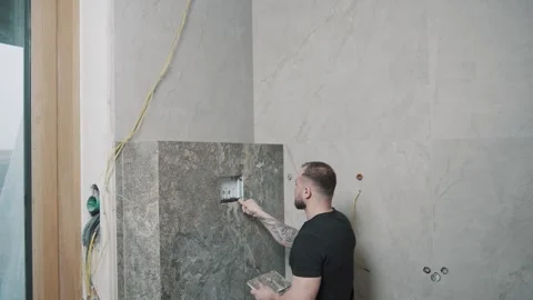Man installing tiles in a modern interior setting Video stock 307041198