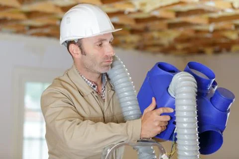 Man installing a ventilation box Stock Photos