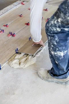 Man installing wood effect floor tiles in new home Stock Photos