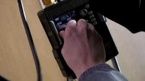 Man installs and setups power supply for lighting equipment Видео 324915393